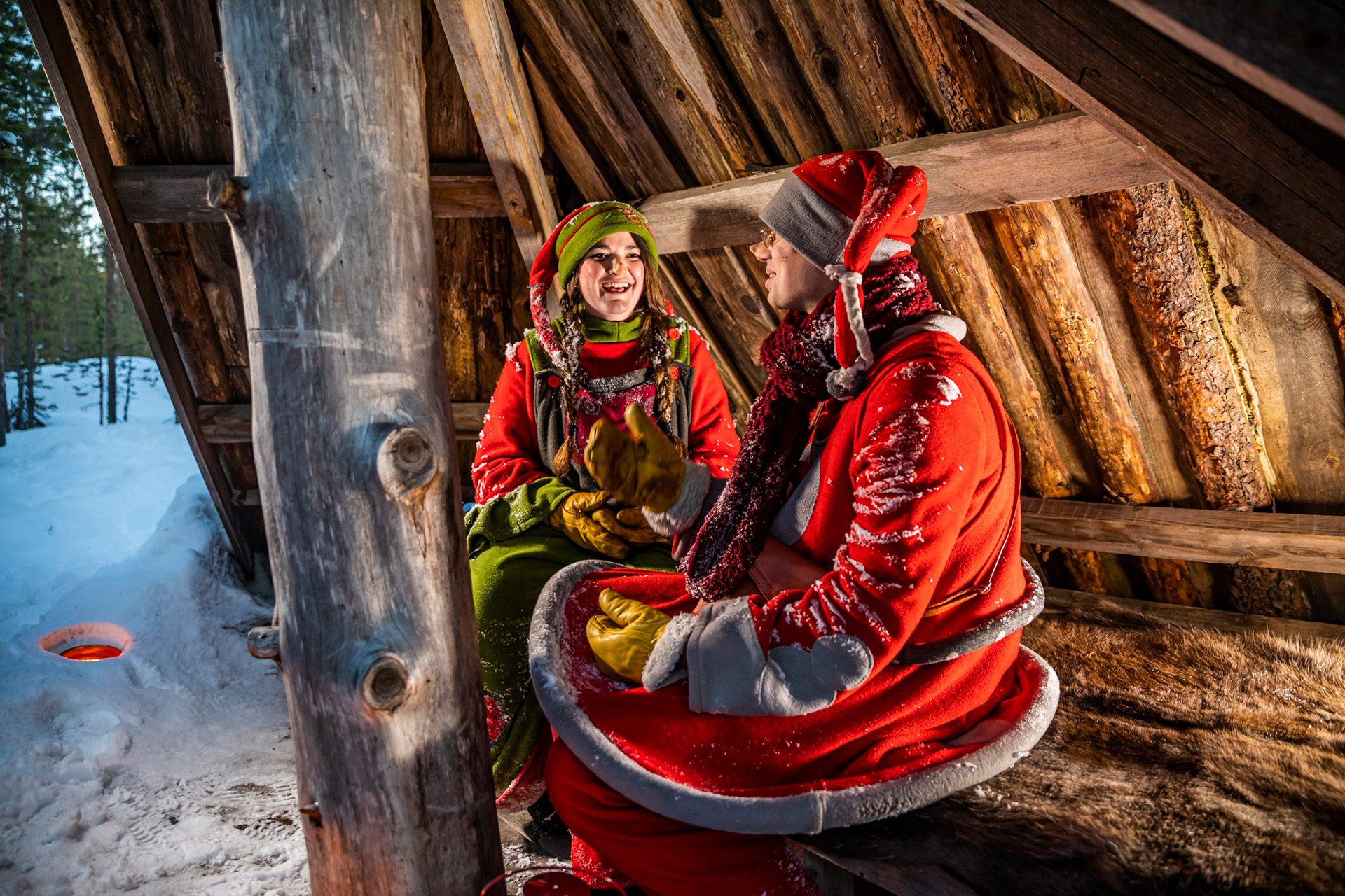Elves sitting in the laavu at the Santa Claus Secret Forest Joulukka.