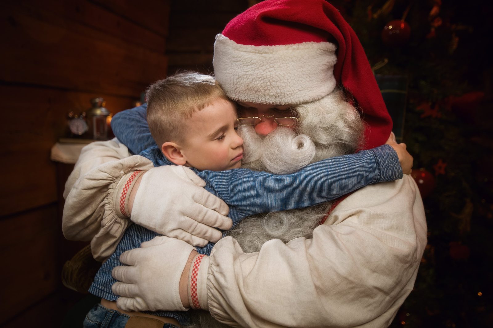 a child hugging santa claus in Joulukka Forest Hut