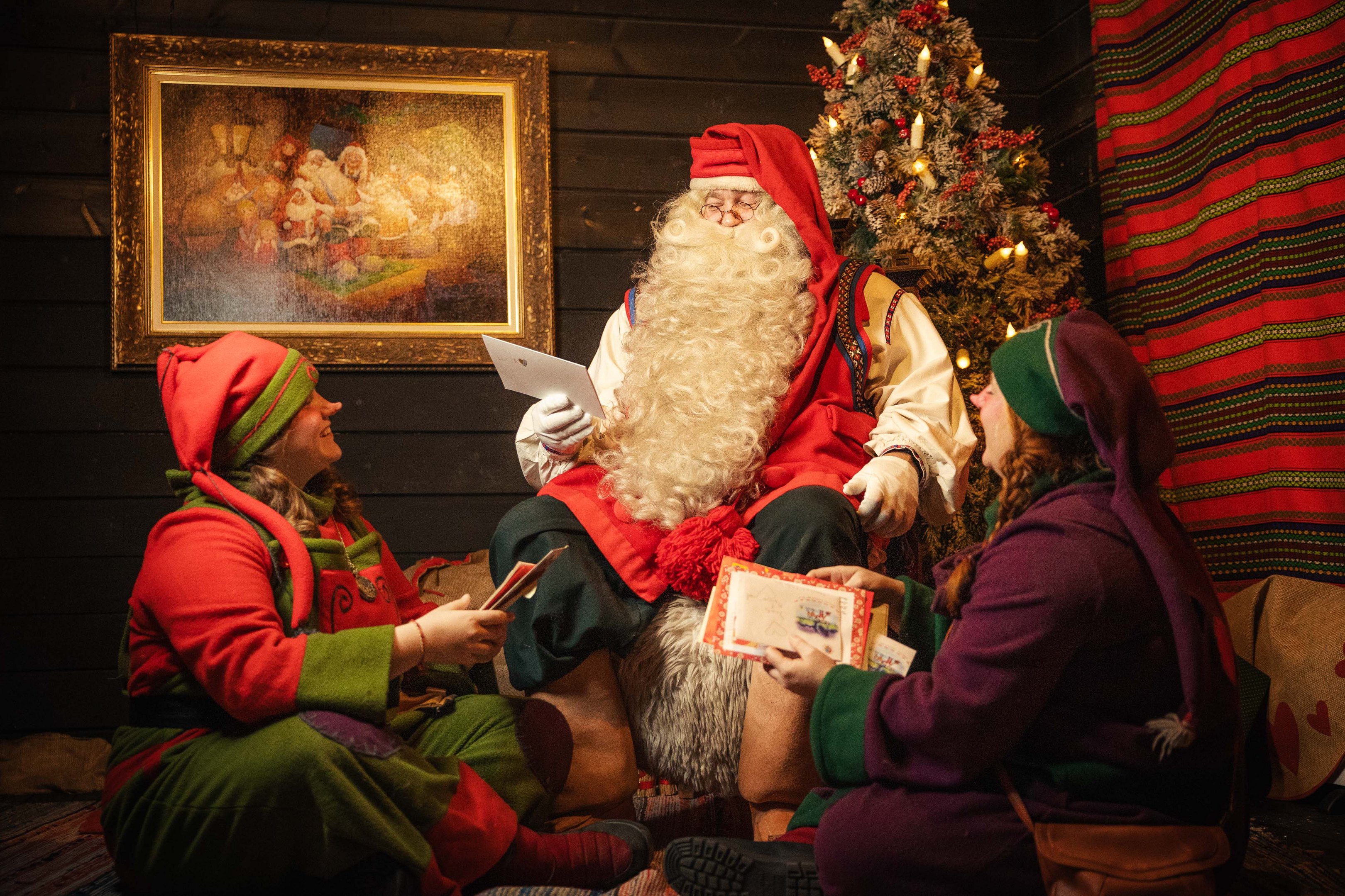 Santa Claus with Elves reading letters in Santa Claus Secret Forest Joulukka Lapland